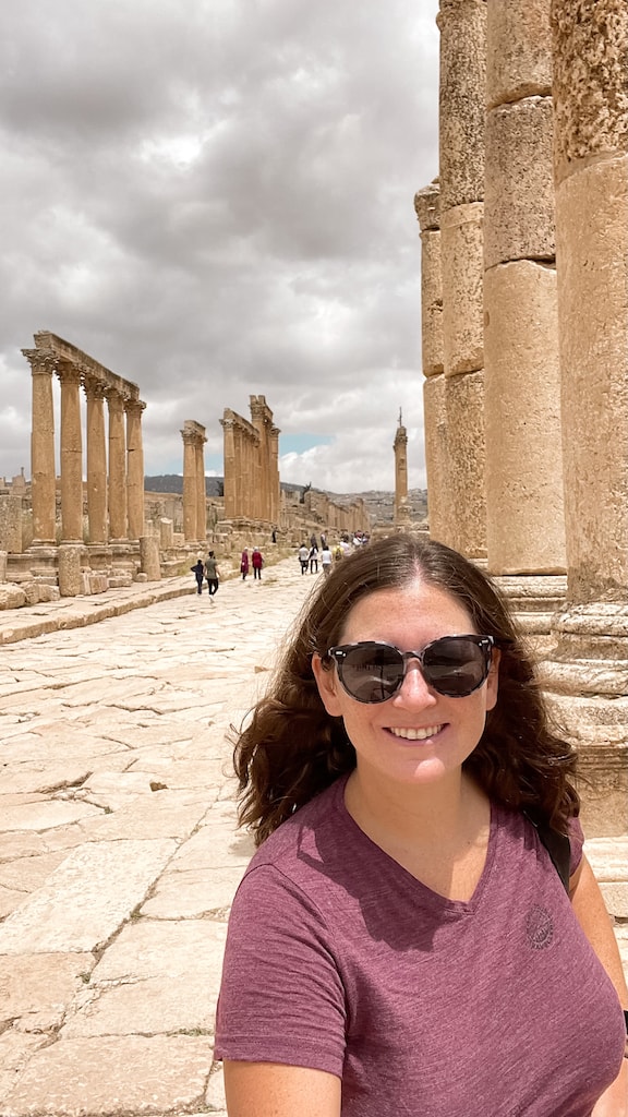 A selfie of me standing on an ancient roman road with pillars still standing on either side in Jerash, Jordan.