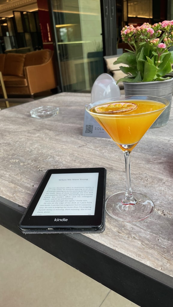 Kindle and fruity martini sitting on a table at a restaurant in Amman, Jordan.