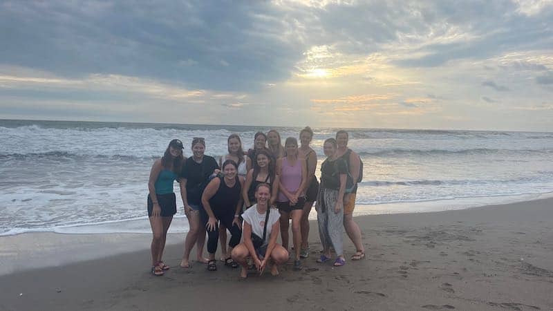 12 solo female travelers on a tour together on Las Penitas Beach in Nicaragua.