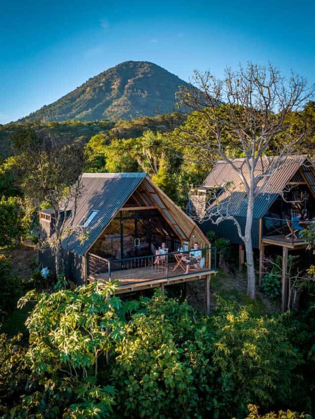 Stunning aerial view of eco-friendly cabins with a mountain backdrop at a hotel in Ruta de las Flores, perfect for travelers looking for a unique and immersive nature stay.