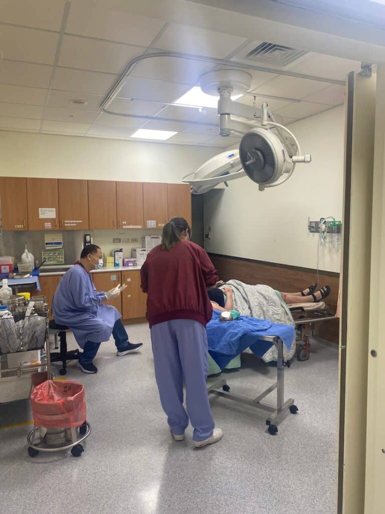 Interior of a Taiwanese hospital with a focus on a medical professional stitching a wound, representing affordable and efficient medical care for tourists.