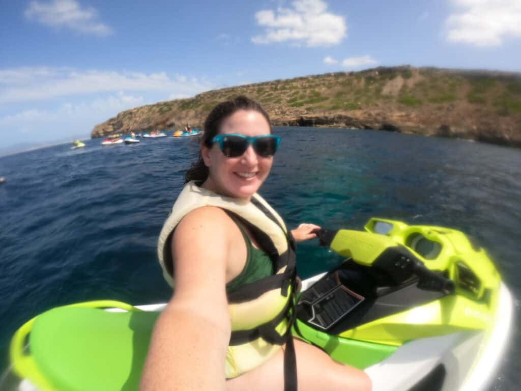 A solo female traveler enjoys a thrilling jetski ride on the blue waters off the coast of Mallorca, Spain. Perfect for solo travel captions, this photo captures the excitement and beauty of water sports in the Mediterranean.